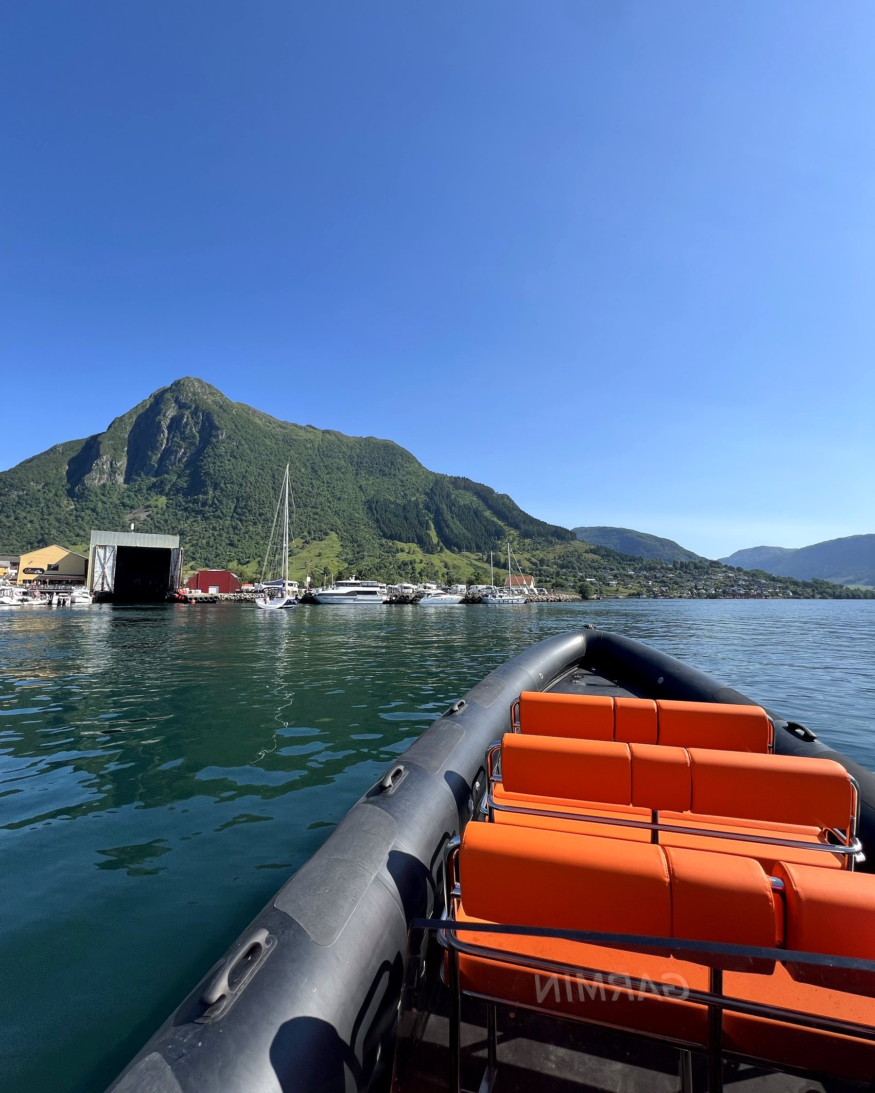 Orange saddle seats on board the RIB with the fjord ahead